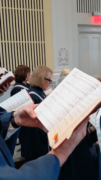 Looping image of choir singing during a service from the perspective of in the choir